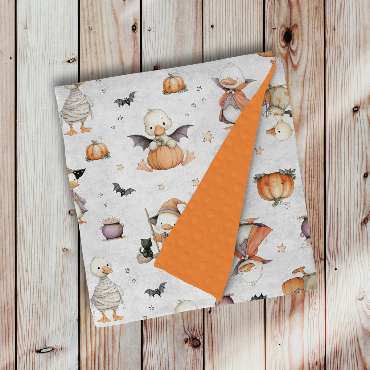doudou, couverture en minky avec endos en minky dot, à pois, texturé, ultra douce, motif halloween chez les oies avec endos orange papaye, avec oie blanche costumé, citrouille, fantôme, chauve-souris, momie, sorcière, chat noir, potion par 4Timini 